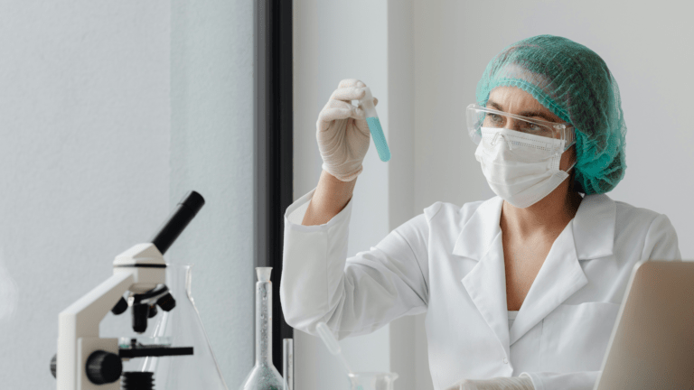 Laboratory researcher examining a blue sample in a test tube beside a microscope and glassware for tesofensine research